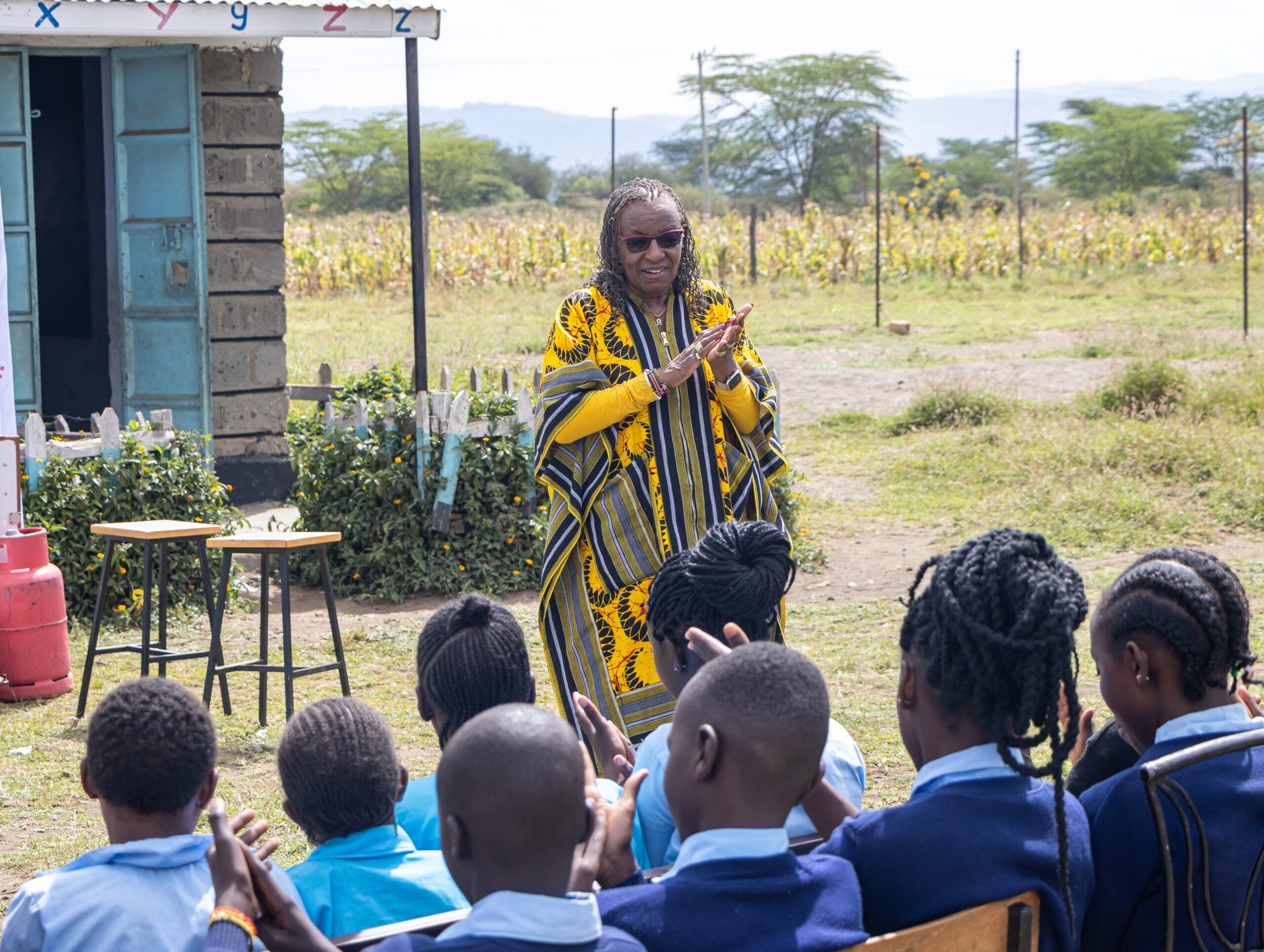 An ENAF facilitator addresses a group of schoolchildren seated outdoors