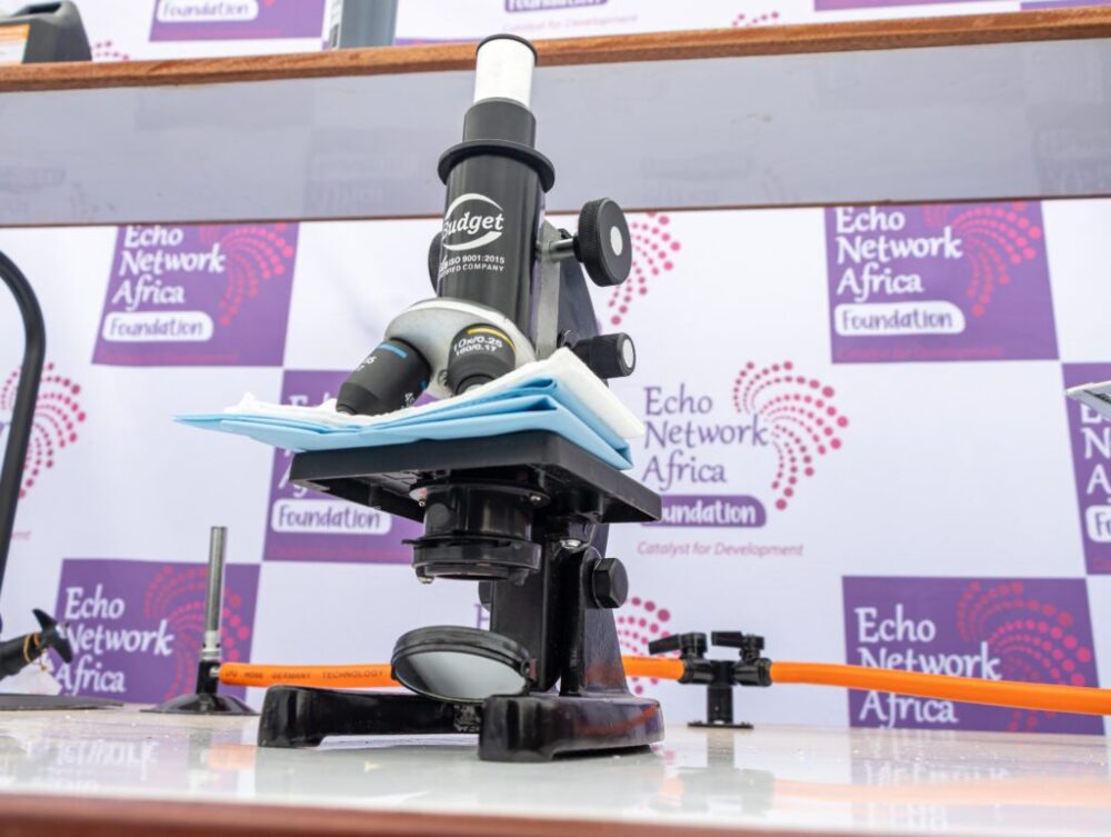 A microscope from a Mobile Science Lab in front of ENAF banners